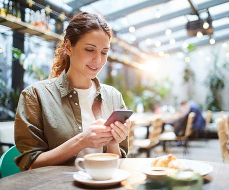 Woman using phone in cafe