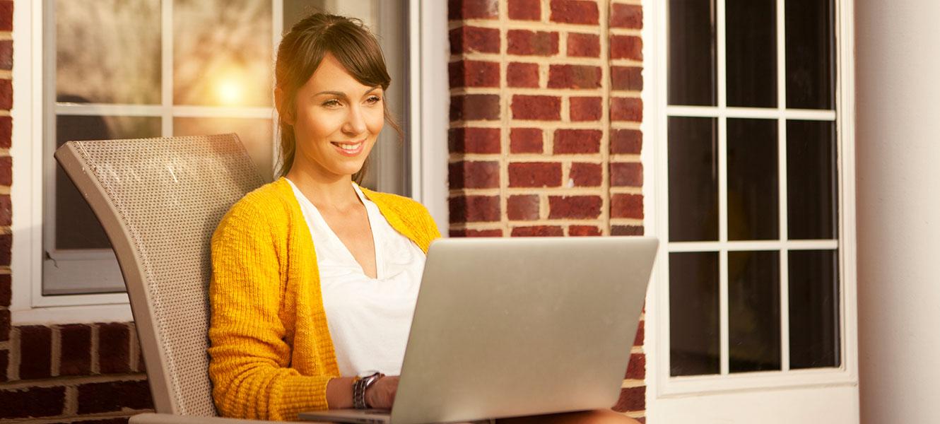 Woman using laptop on porch