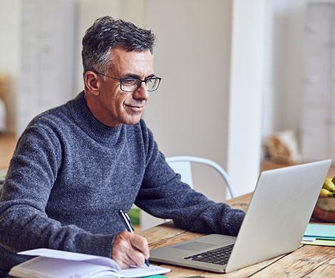 Man working on computer in kitchen