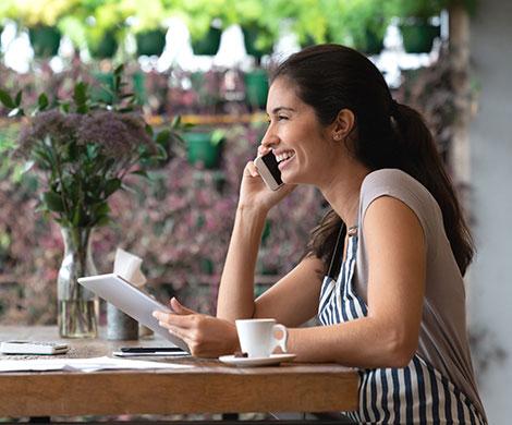 Woman talking on phone while using tablet