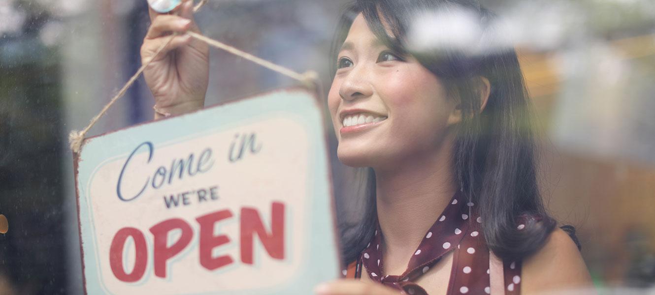 Business owner hanging up open sign at store